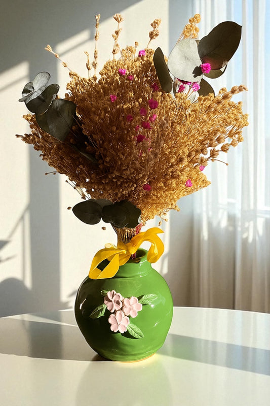 Jarra decorativa artesanal en cerámica verde con flores en relieve