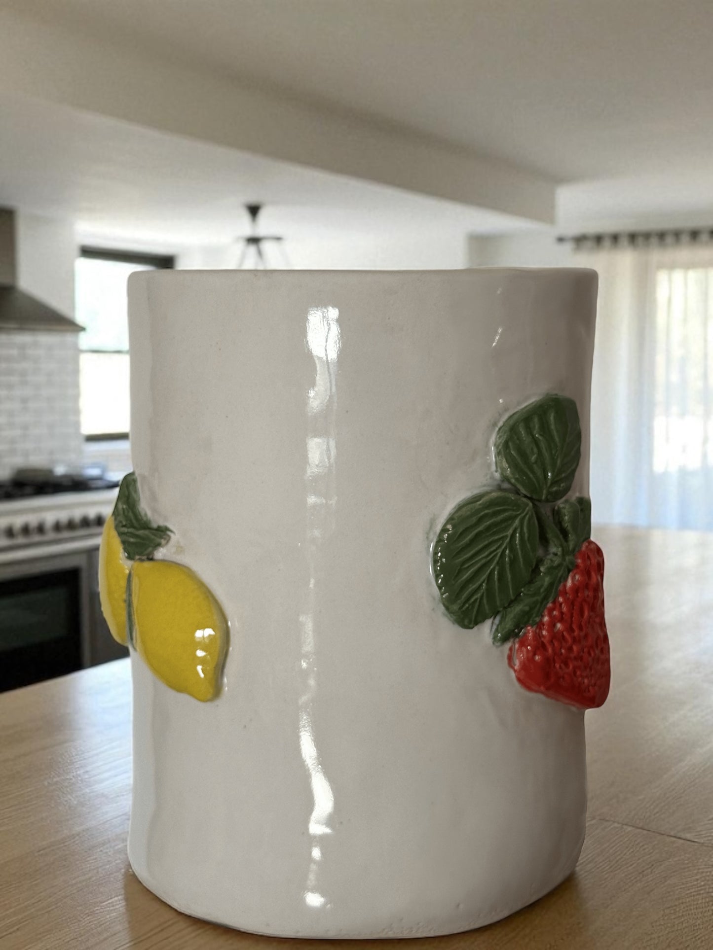 Jarra de cerámica con frutas en relieve